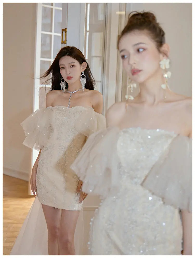 a shimmering white off-the-shoulder cinched waist miniskirt fairy dress featuring intricate beading and delicate ruffled sleeves