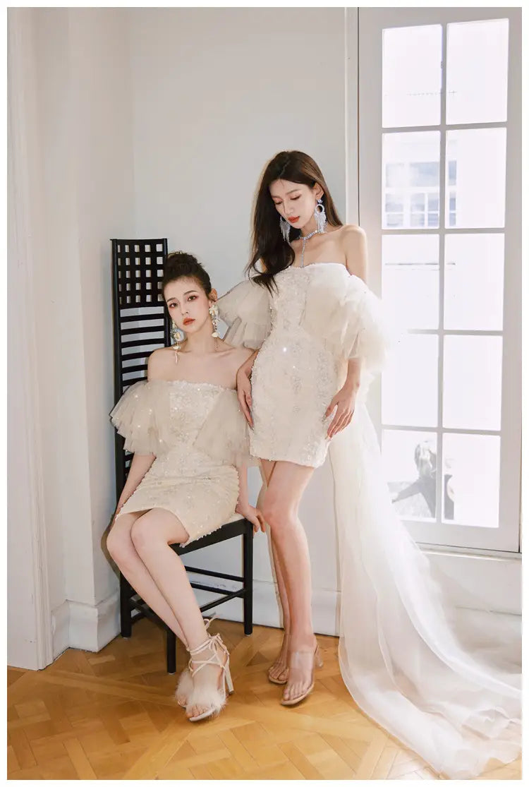 off-white sequined mini dress with sheer ruffled sleeves and a flowing train featuring a cinched waist miniskirt fairy design.