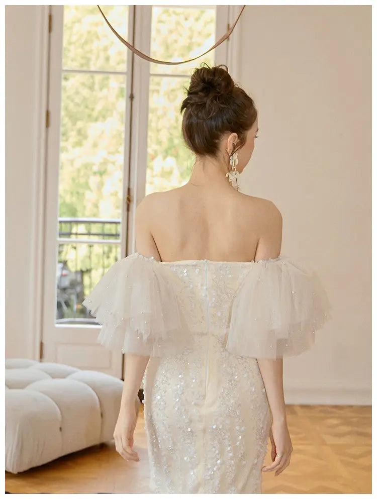 a shimmering white off-the-shoulder ivory lace cinched waist miniskirt fairy dress featuring delicate ruffled sleeves and a sequined bodice