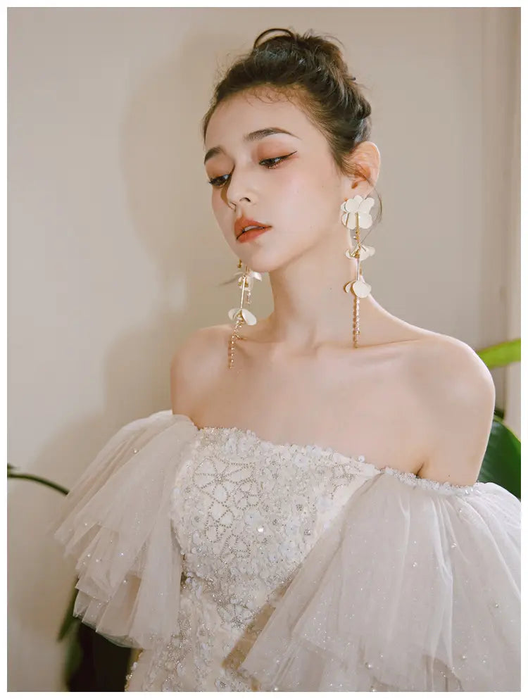 Elegant off-the-shoulder ivory lace cinched waist miniskirt fairy dress featuring intricate beading and layered tulle sleeves.