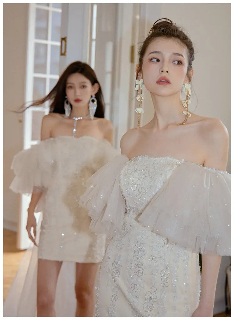 a shimmering white off-the-shoulder ivory lace cinched waist miniskirt fairy dress featuring delicate lace detailing and voluminous ruffled sleeves