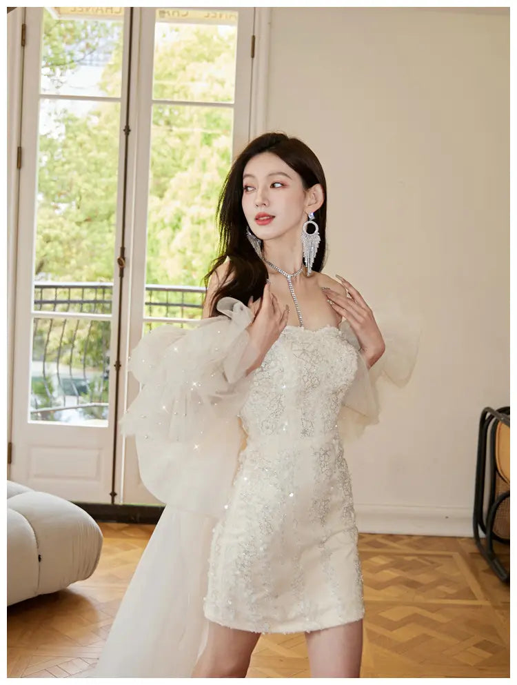 Ivory lace cinched waist miniskirt fairy dress featuring a white embellished mini dress with delicate lace detailing and sheer puff sleeves.