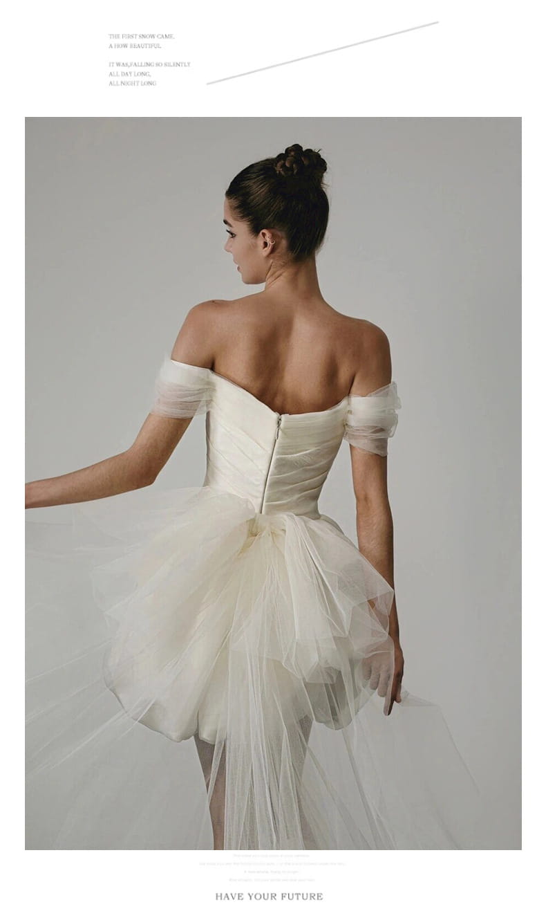 A white off-shoulder wedding dress with a structured bodice and layered tulle skirt featuring a train, ideal as a light wedding dress white.
