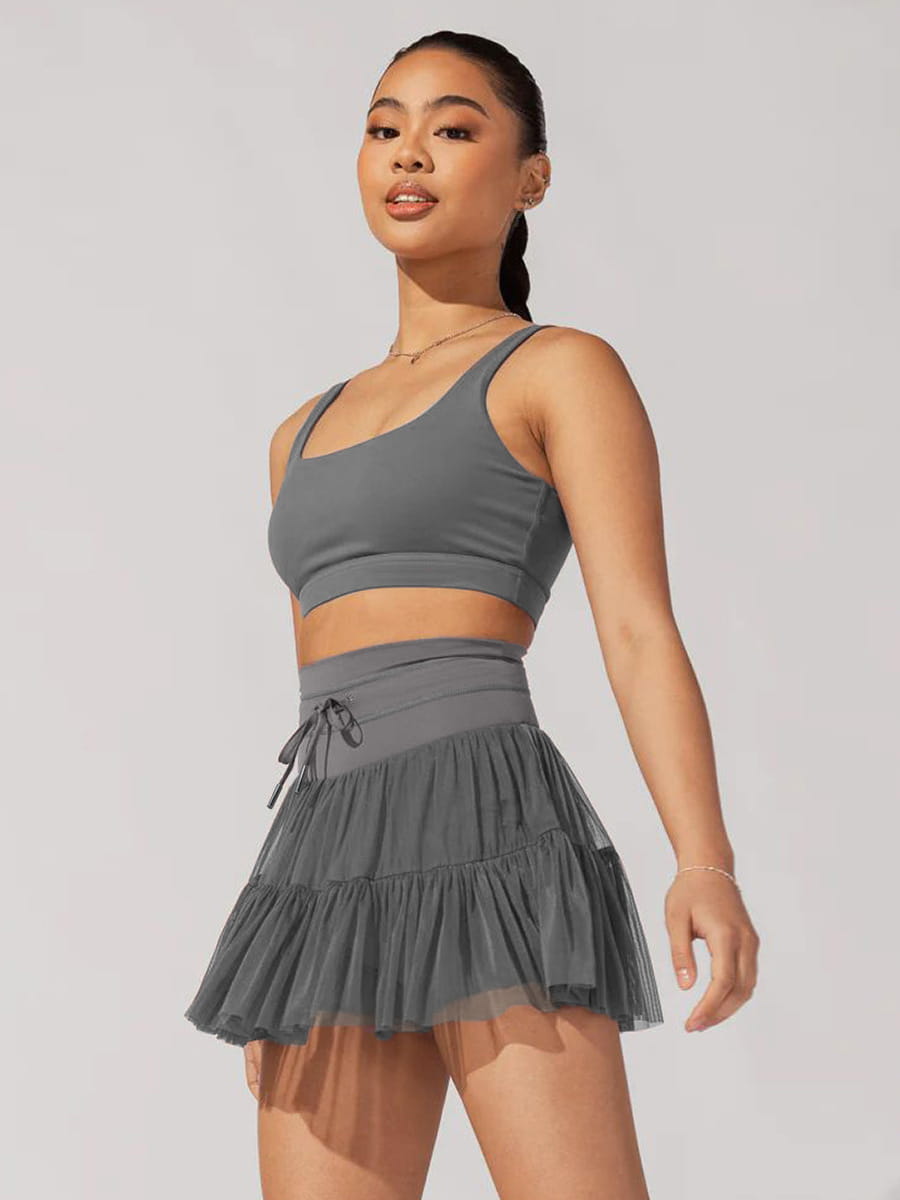 gray tiered mesh skirt with matching crop top paired with white high waist pleated skirt featuring safety pants for summer use