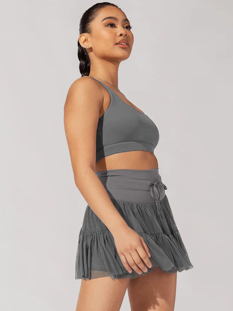gray ruffled mini skirt with matching crop top paired with white high waist pleated skirt featuring safety pants suitable for summer wear