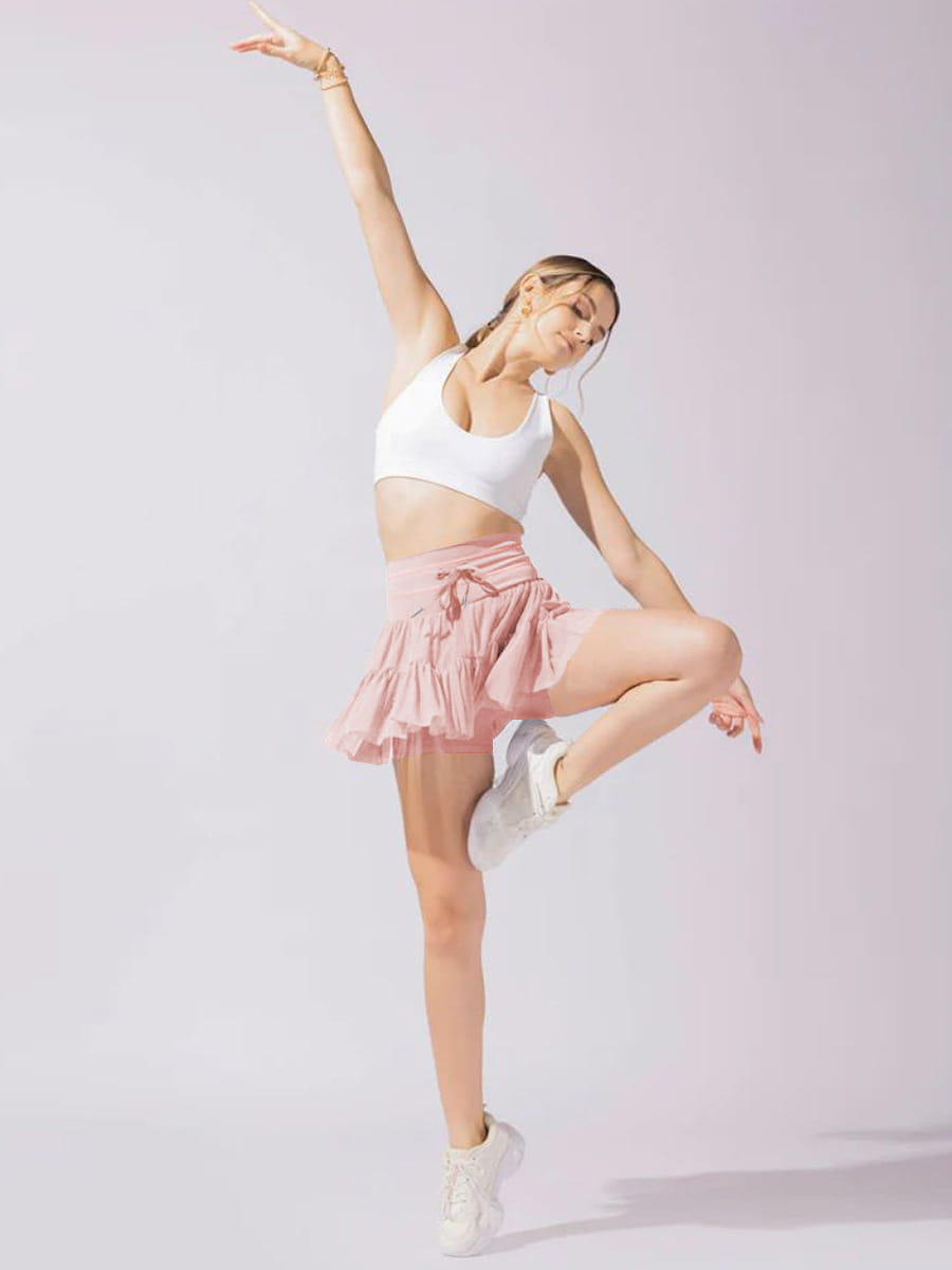 a soft pink pleated skirt with a high waist tied waistband paired with safety pants summer style