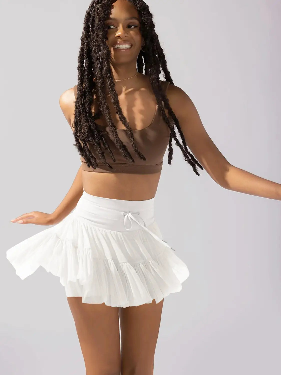 white pleated skirt with a high waist drawstring waistband featuring safety pants designed for summer wear