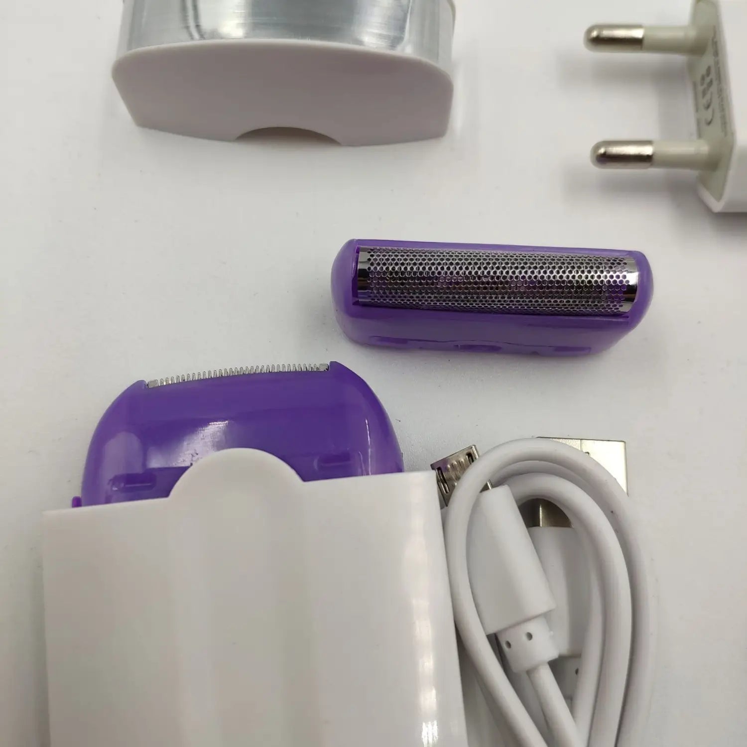 Electric hair removal device with a purple and white body and a metallic sensa-light head designed for effective hair removal.