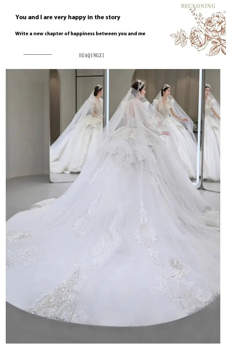 a flowing white french retro bride main yarn long sleeve wedding gown with intricate lace detailing and a voluminous yarn long train