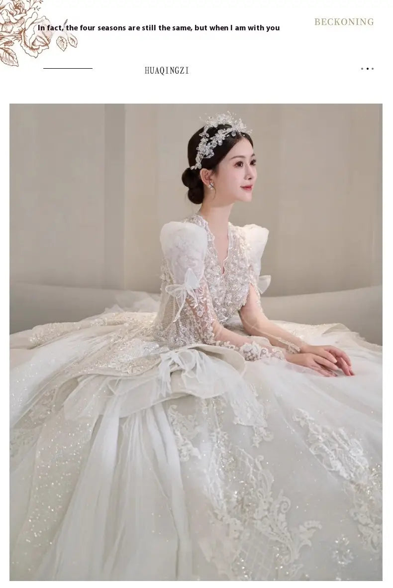A white lace bride main yarn wedding gown featuring intricate floral embroidery and voluminous yarn long sleeve design.