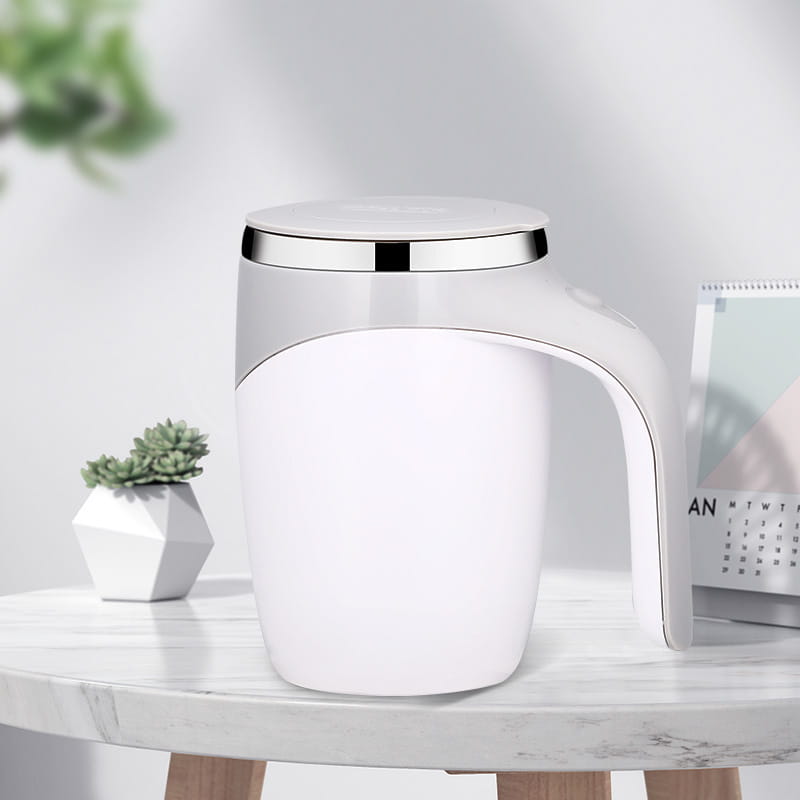White ceramic rechargeable model automatic stirring cup with a sleek silver rim and handle designed for modern kitchen use.