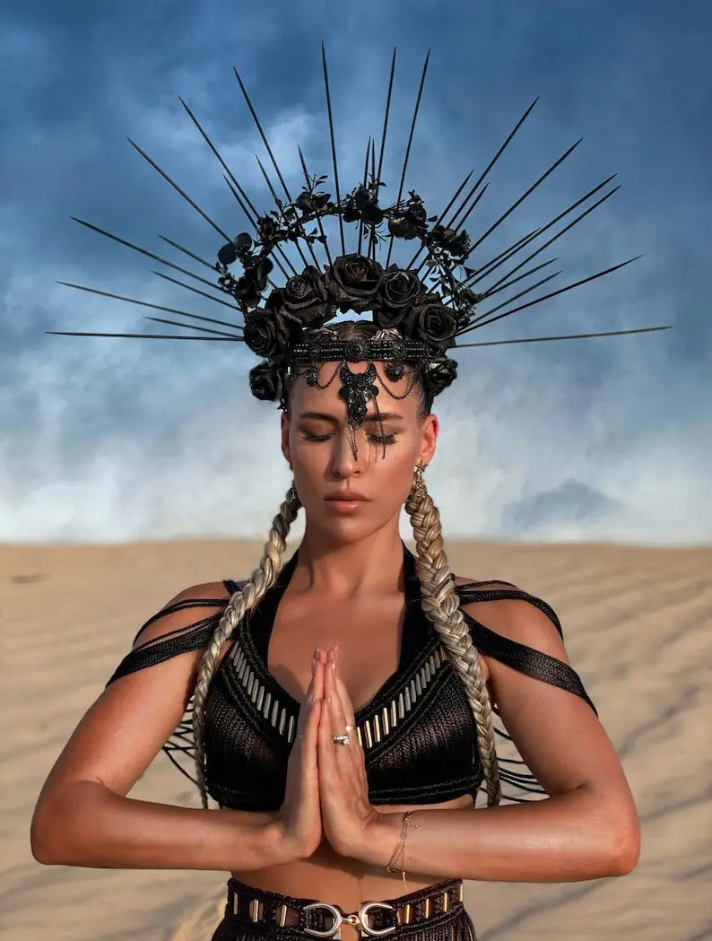 black spiked crown adorned with roses and intricate metalwork complements beige macramé tassel dress creative beach travel set.