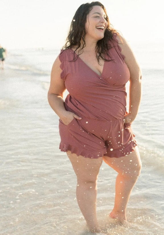 a soft mauve romper with ruffled sleeves and hem and a flattering wrap-style front paired with a teal ruffled deep v one-piece swimsuit featuring a built-in bra suitable for bra hot spring or hot spring boxer use