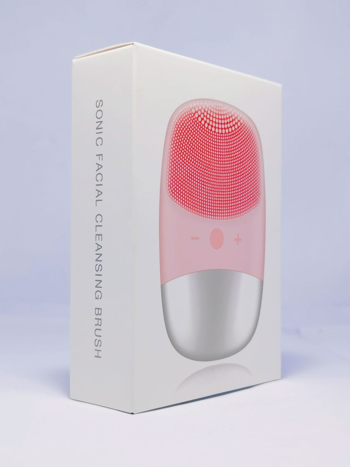 Mini silicone electric facial cleanser brush with pink and silver body and a textured dotted silicone cleansing brush head.