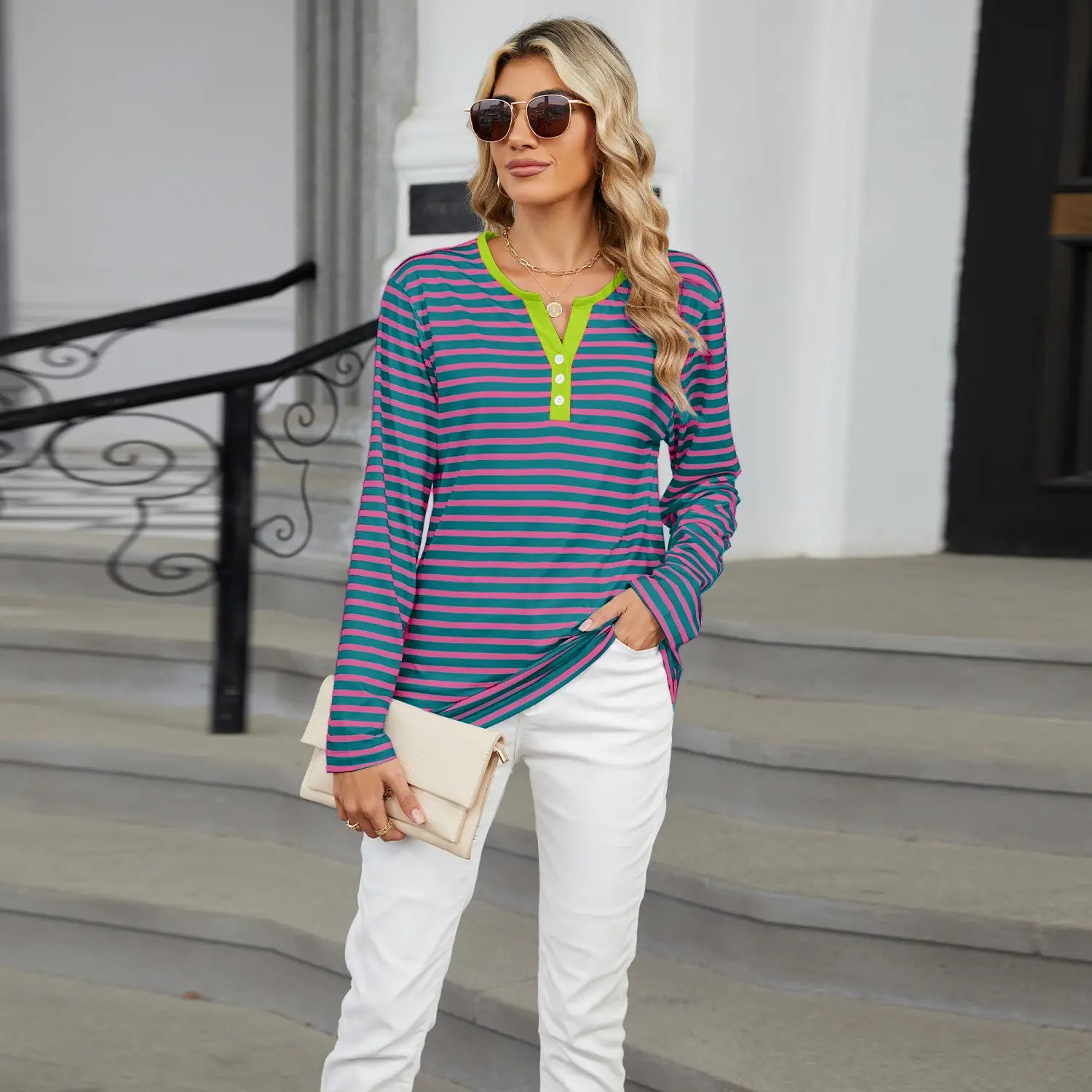 women’s v-neck striped loose henley top featuring long sleeves and horizontal stripes in teal and magenta with a bright lime green collar and placket.