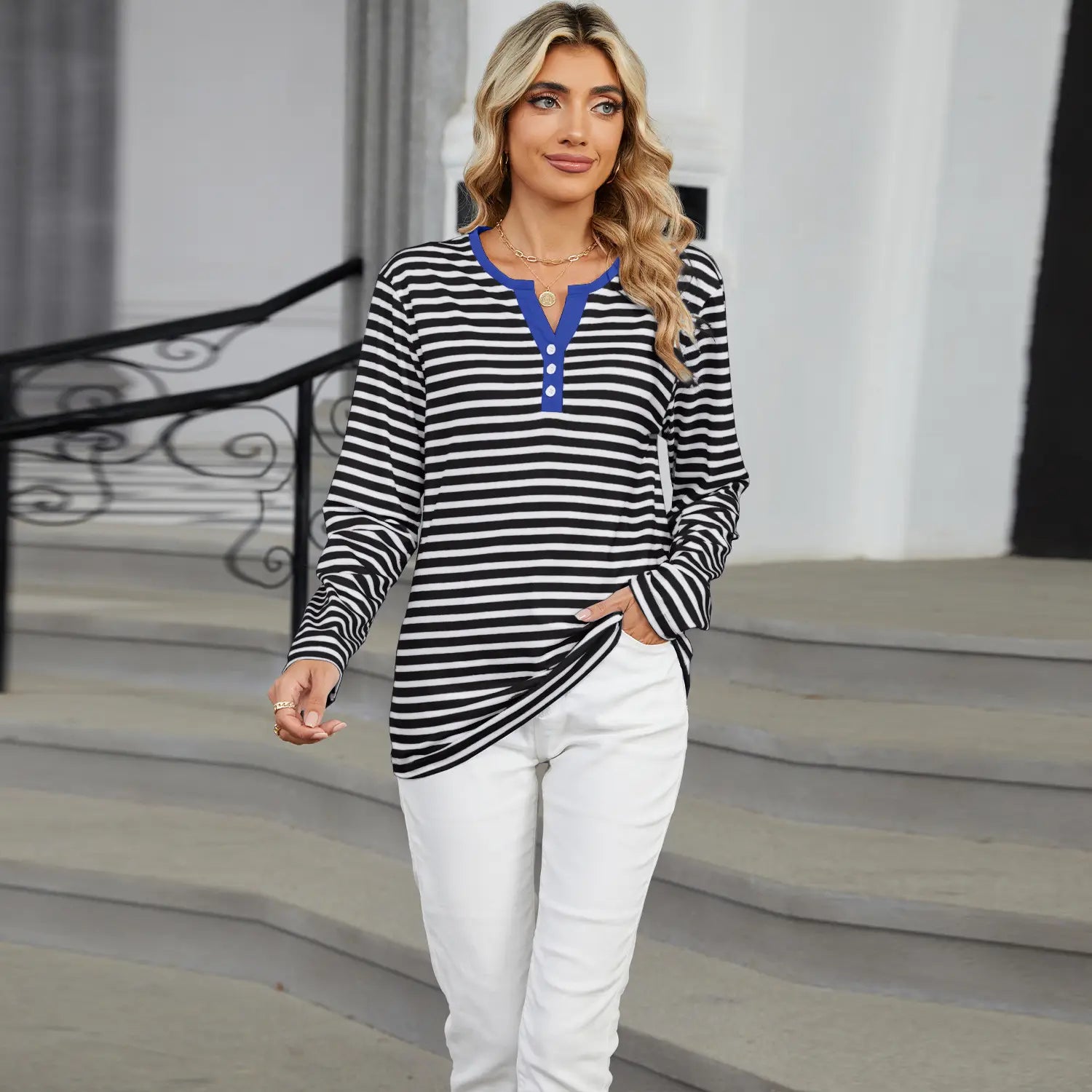 Women’s v-neck striped loose henley top with black and white stripes and a blue collar and button placket.