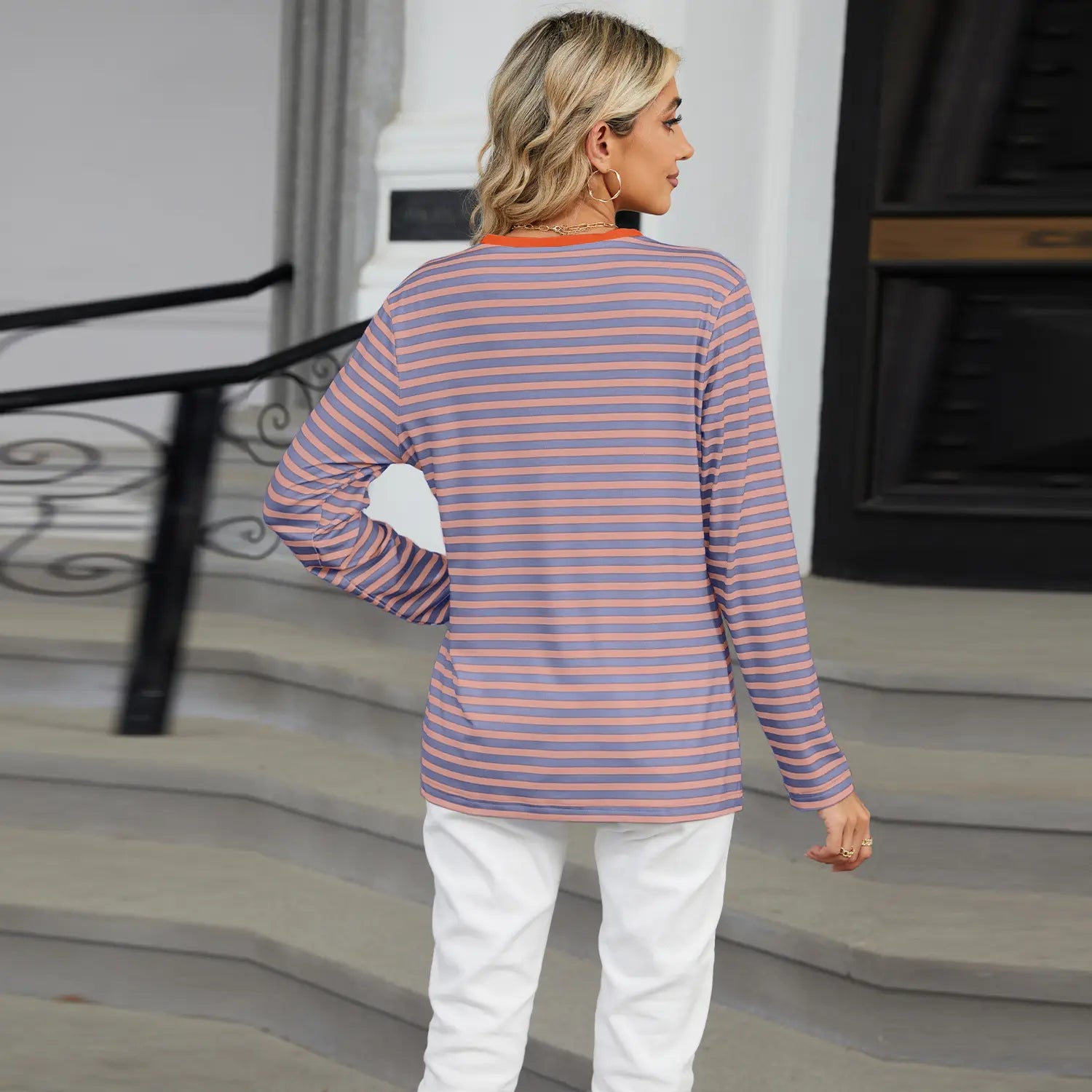 a soft women’s v-neck striped loose henley top featuring long sleeves and horizontal stripes in muted purple and peach tones