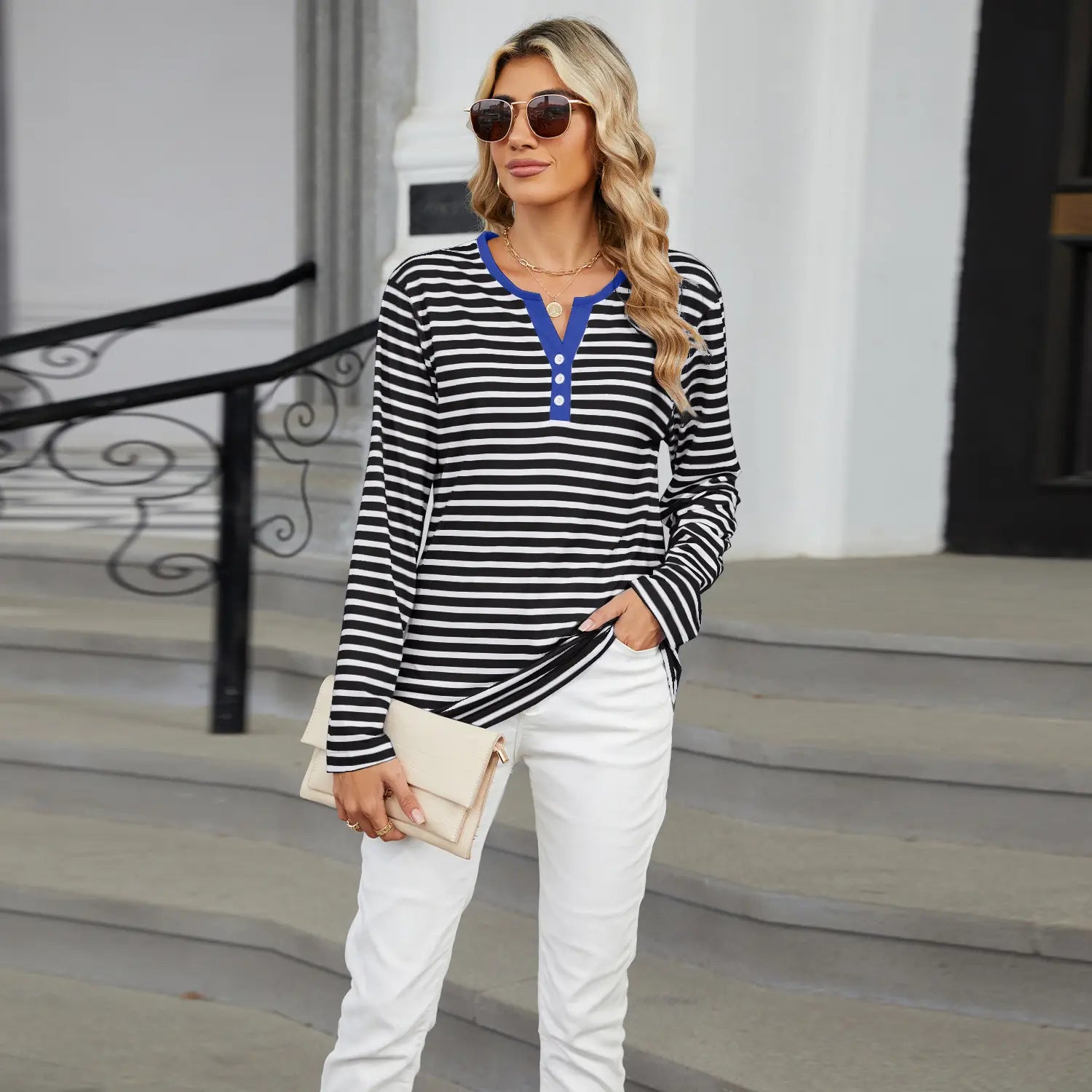 Women’s v-neck striped loose henley top featuring black and white stripes, a long-sleeve design, and a contrasting blue collar with a three-button placket.