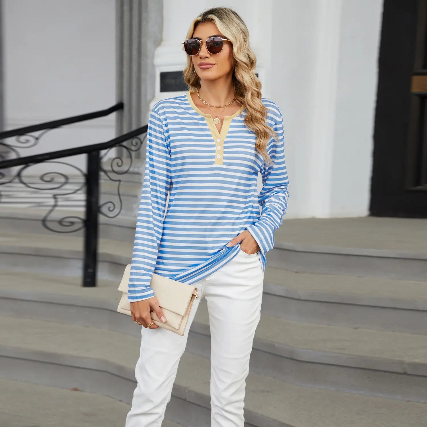 women’s v-neck striped loose henley top featuring blue and white stripes with a beige collar and button placket in long sleeves.