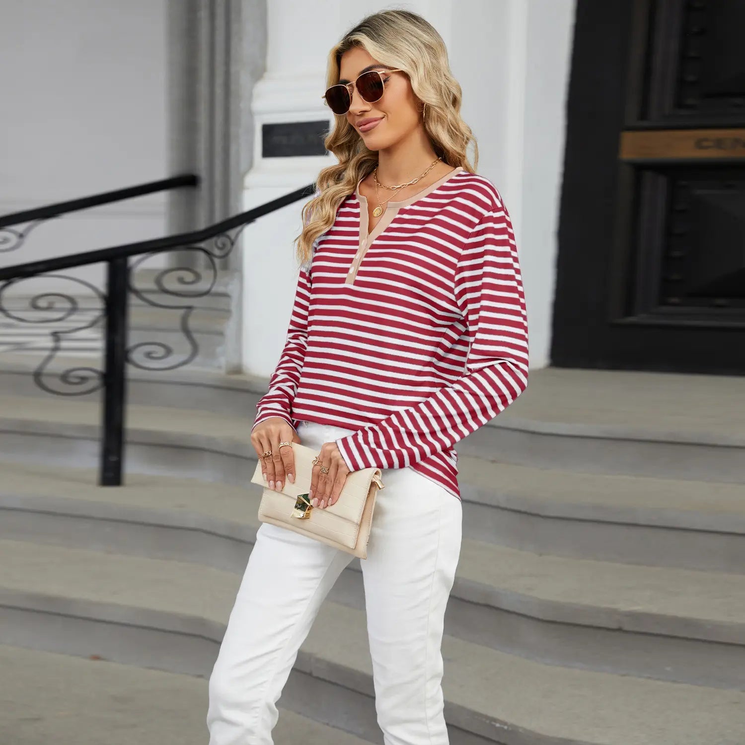 a woman wearing a red and white women’s v-neck striped loose henley top with long sleeves
