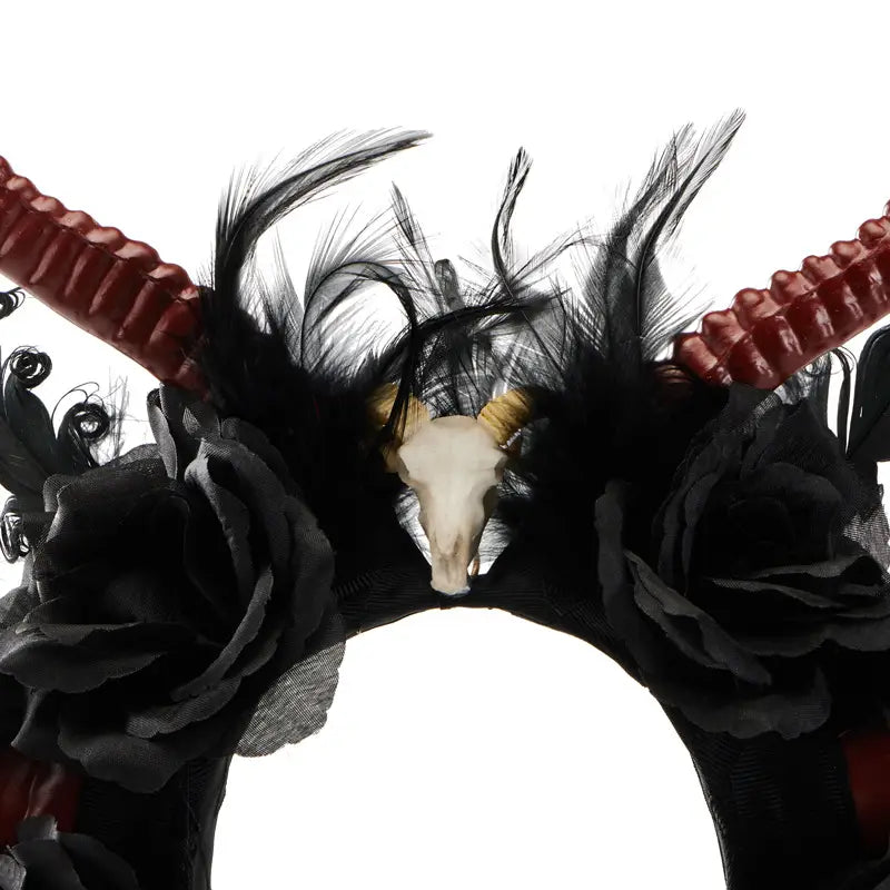 black feathered gothic dark devil headpiece with red textured antelope horns and a central white skull adorned with gold accents