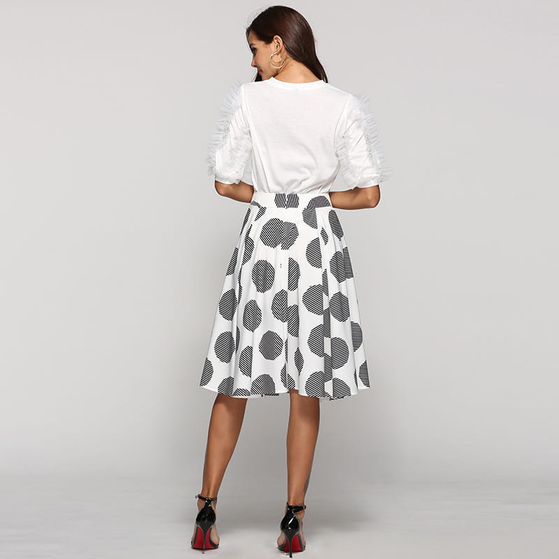 white blouse with ruffled short sleeves paired with a large polka dot round slim fit a-line skirt in black and white.