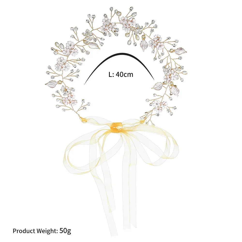 A delicate 40cm pearl handmade headband featuring alloy flower details with silver-toned metal, clear and pink crystals, and a soft yellow ribbon bow.
