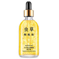 A clear glass bottle of 24k gold pure hyaluronic acid essence serum with gold-toned dropper and biaoquan ginseng essence label