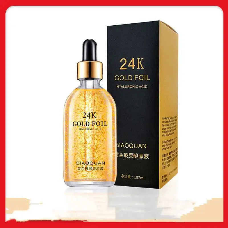 A transparent glass bottle of 24k gold pure hyaluronic acid essence serum with black dropper and gold foil accents by biaoquan