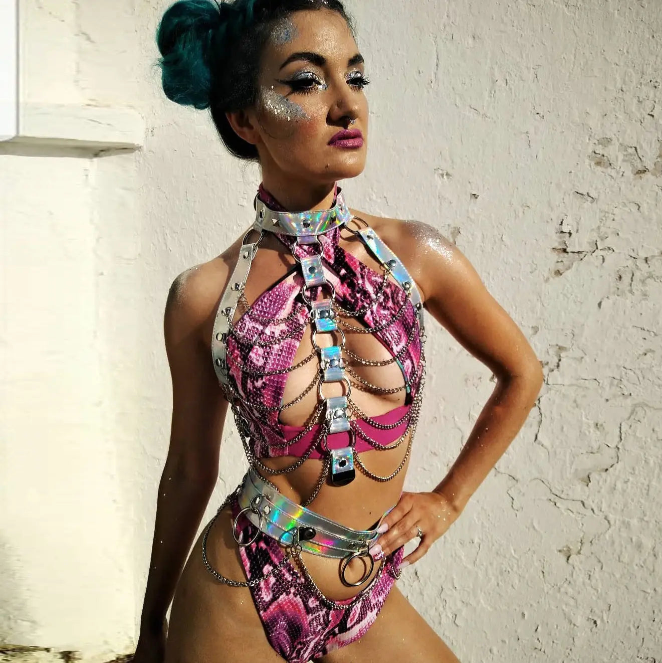 Creative versatile laser ladies belt bodysuit in a shimmering pink and silver snakeskin pattern with metallic chains, buckles, and holographic accents.