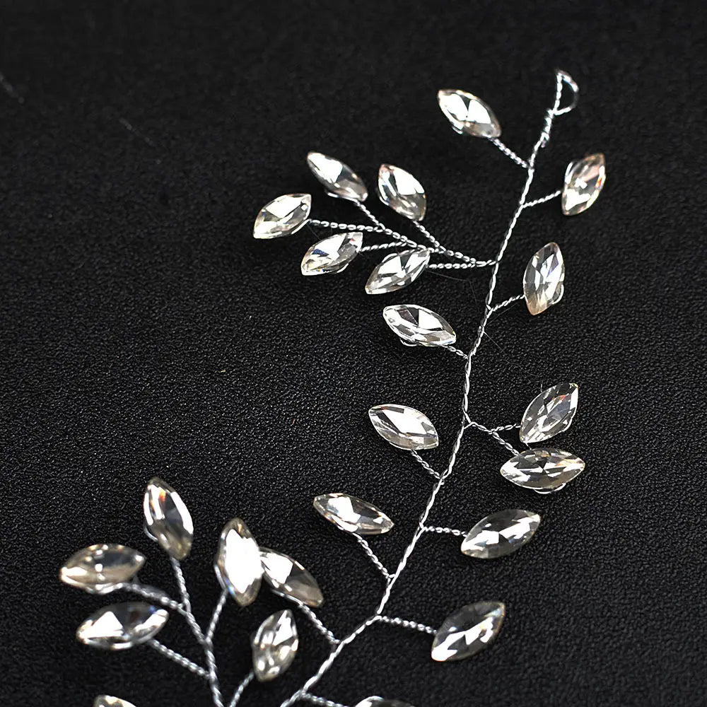 A delicate silver flexible chain horse eye silver wedding hair accessory featuring clear faceted crystal leaves on a wire hair vine.