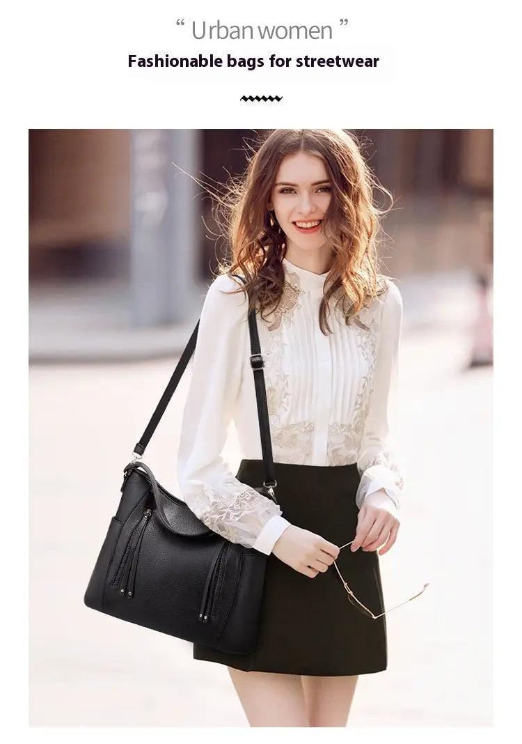 Black leather shoulder bag with tassel details showcasing large capacity luxury women leather design for everyday use.