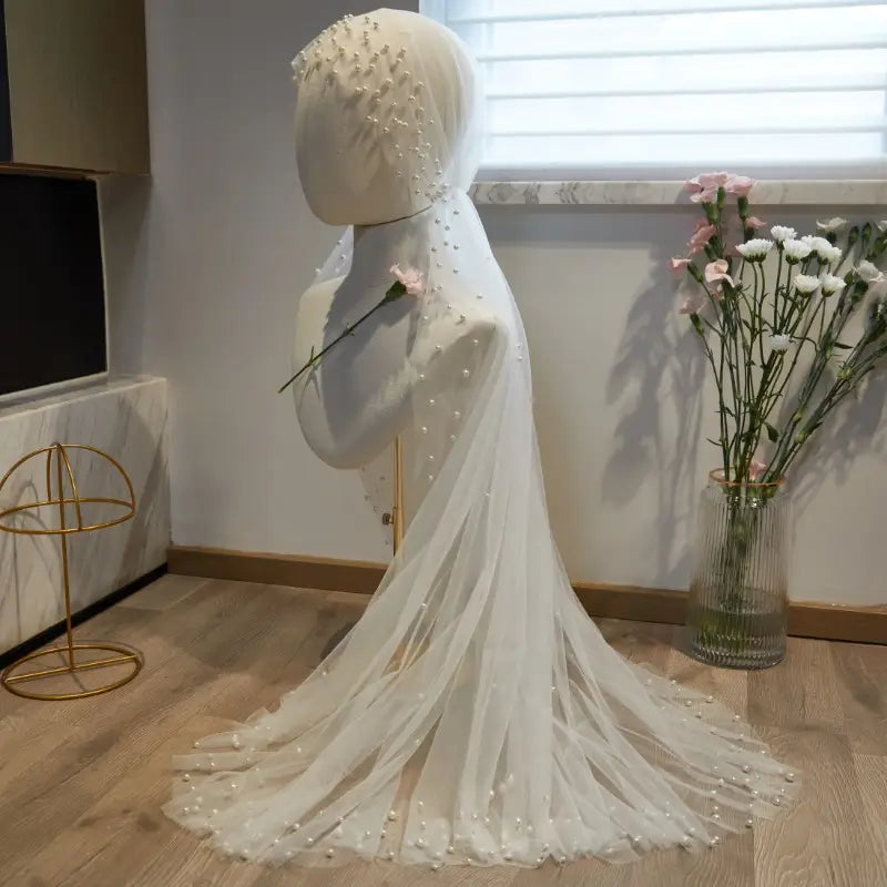 A delicate white super fairy long pearl veil bridal hijab featuring scattered pearls and soft flowing tulle fabric.