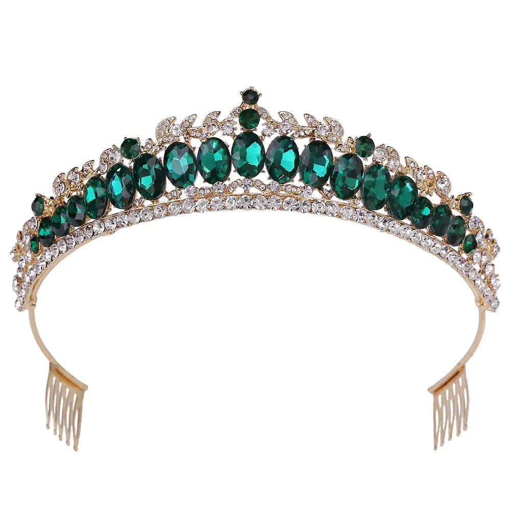 A sparkling gold fashion bridal knot tiara adorned with oval emerald green crystals, smaller clear rhinestones, and leaf-like metalwork accents.