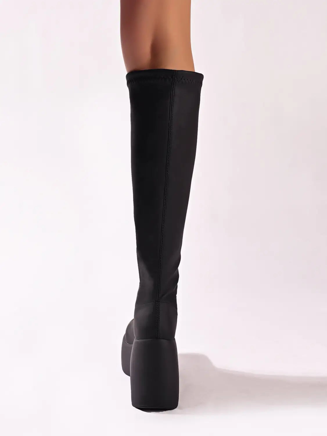 Black platform knee high elastic leather boots with a sleek stretchy fabric upper and a thick block heel.