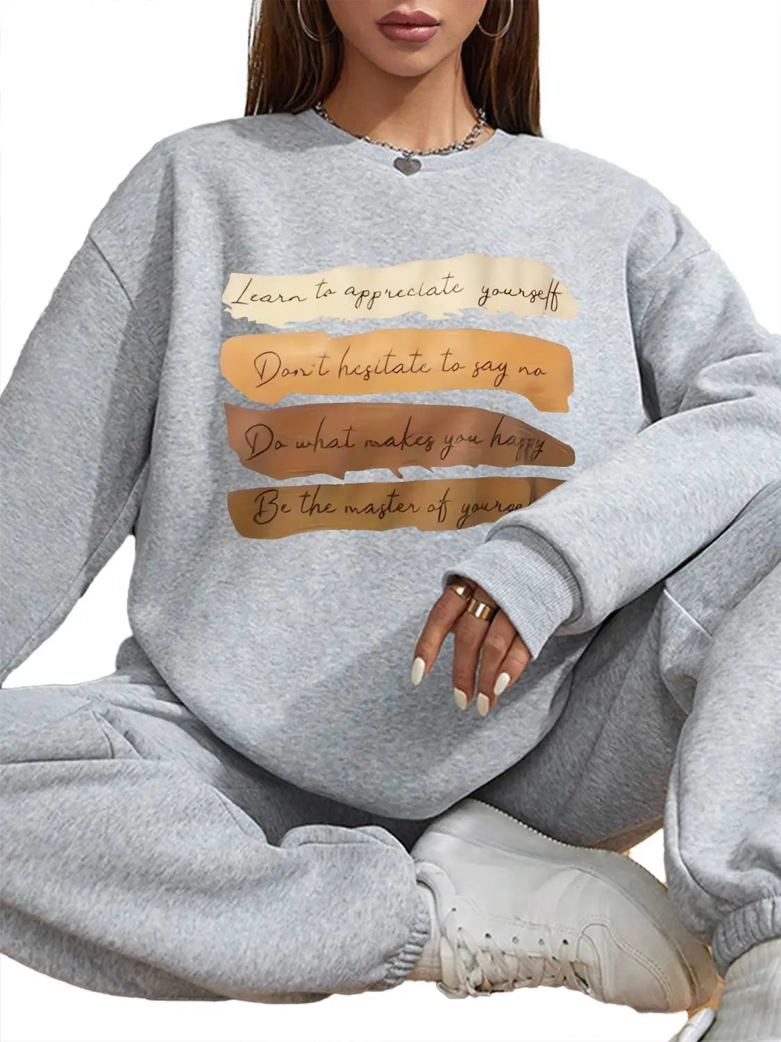 White oversized long sleeve sweatshirt in gray solid colour with a motivational quote printed in black on beige and brown textured strips suitable for daily wear.