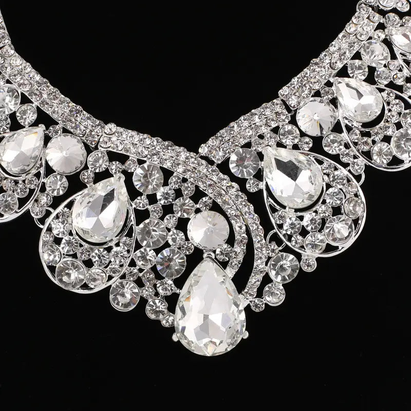 A sparkling silver rhinestone necklace from the united states korean super alloy jewelry set featuring clear teardrop and round crystals in an intricate ornate design.
