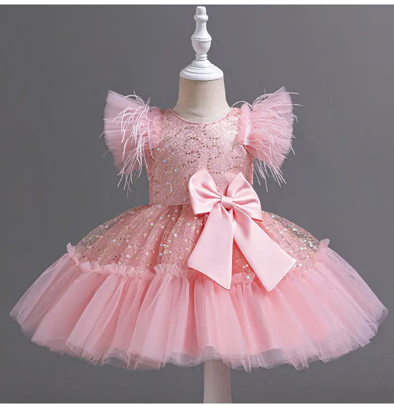 a delicate pink sequined wedding dress tulle with feathered shoulder accents and a matching satin bow at the waist perfect for summer occasions