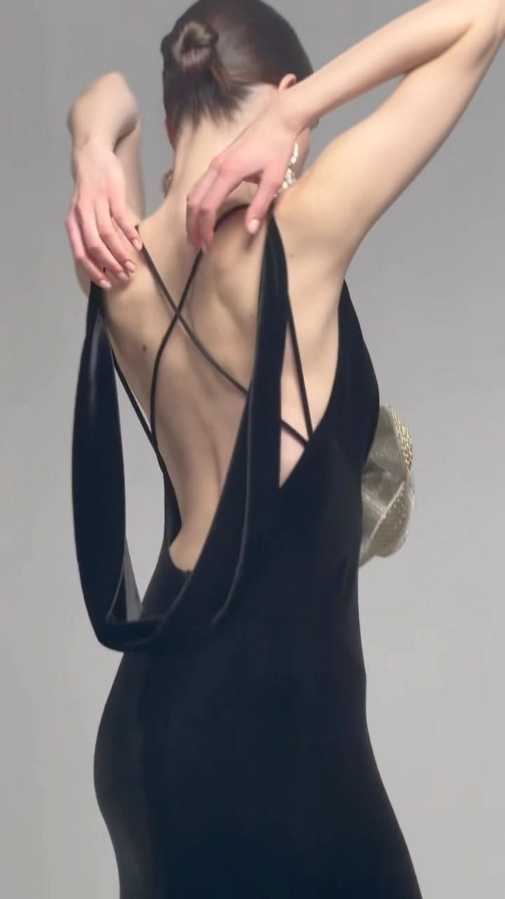 a sleek black camisole backless slim fit velvet floral gown shown from the back featuring a deep cutout and crisscrossing straps