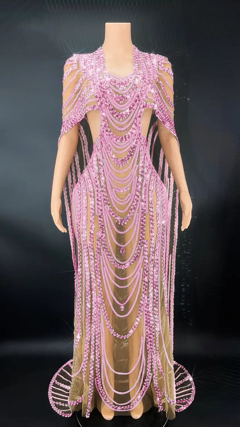 A shimmering pink red beaded celebrate crystal sequin evening gown with cascading strands of crystals and pearls, sheer mesh panels, and a dramatic cape-like overlay.