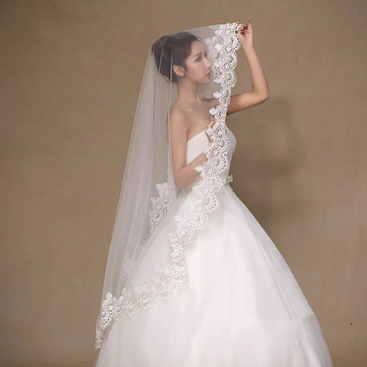 A delicate white lace floral bride veil with intricate patterns and a sheer tulle overlay for wholesale white bride veils.