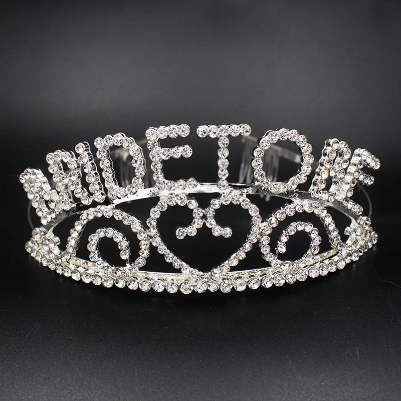 a sparkling silver bridal headband made of rhinestones with an ornate design spelling out queen, a luxury women’s fashion hair accessory.
