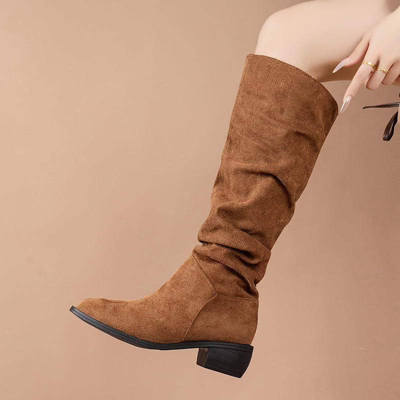Tan suede high leg boot with a low block heel and black sole featuring a sleeve suede high slouchy design.