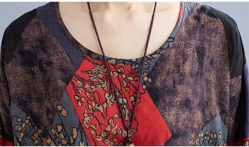 A stylish loose round neck blouse featuring a patchwork design with red, brown, and gray floral printed sections in a loose round neck style.