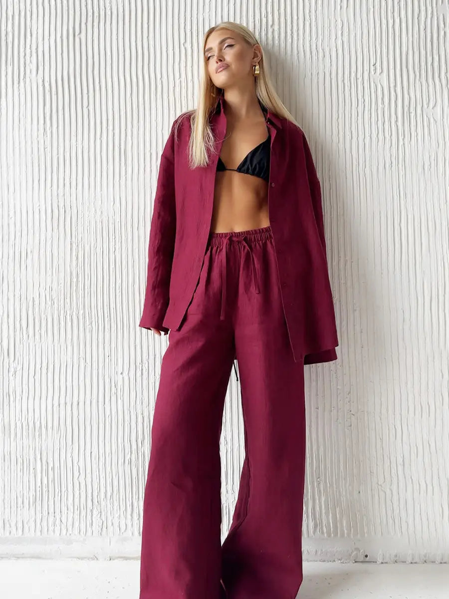 a burgundy linen blazer with a relaxed fit and button closure paired with a white cotton long sleeve shirt trousers suit for a sophisticated look