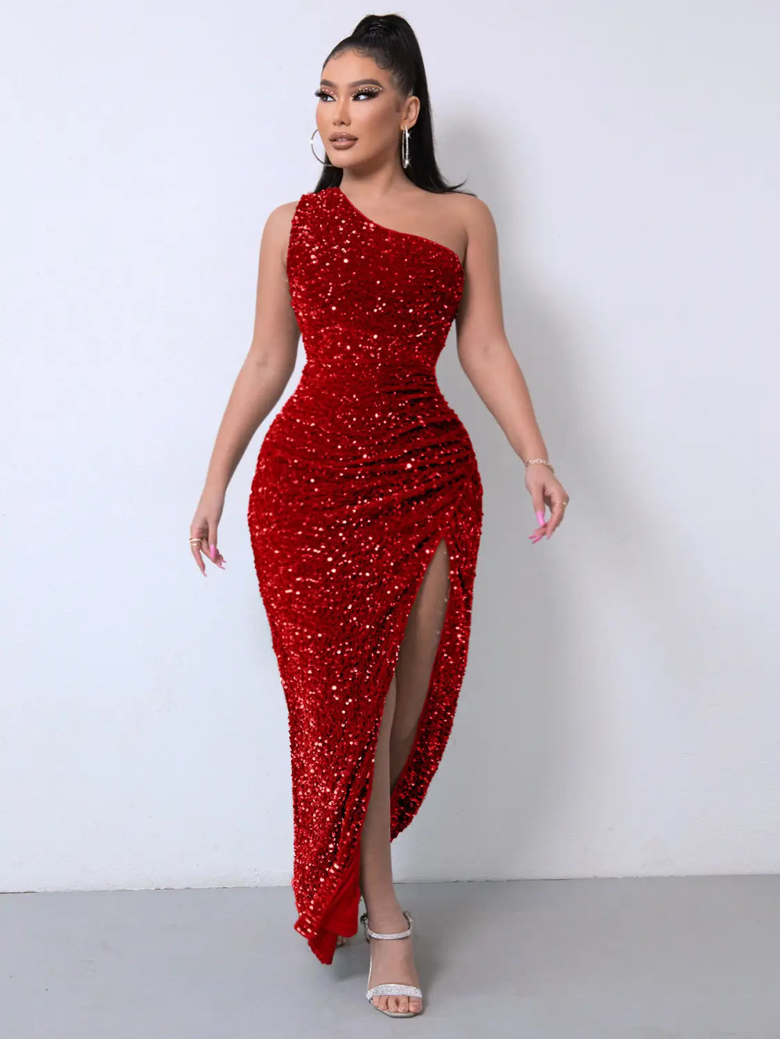 A shimmering red sequined foreign trade sleeveless one shoulder dress with a slash neck and high slit featuring a ruched bodice.