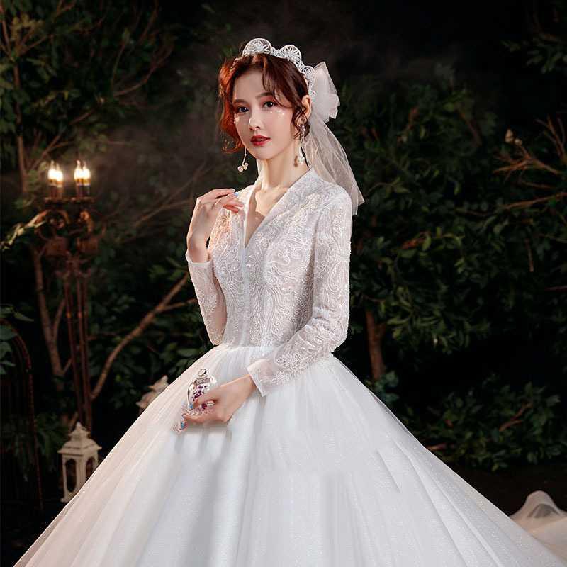 Elegant white wedding gown with intricate lace detailing and trailing long sleeves showcasing the bridal temperament trailing design.