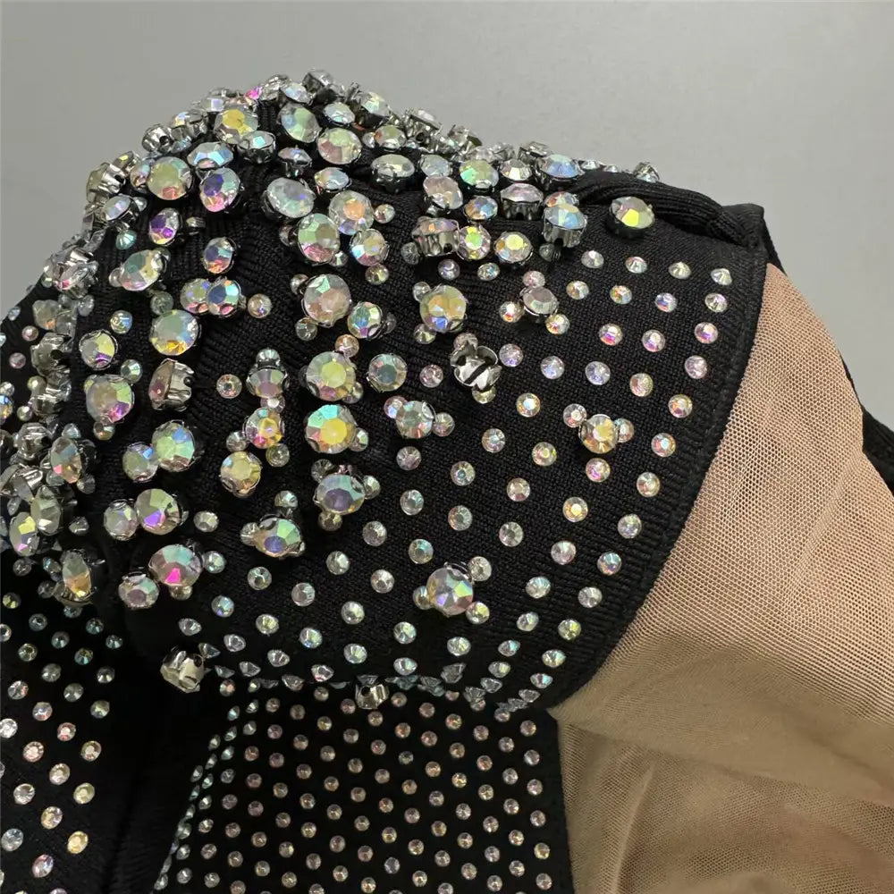 black bodice of a sexy rhinestone bandage long sleeve mini dress adorned with sparkling iridescent rhinestones of varying sizes for cross border foreign fashion.