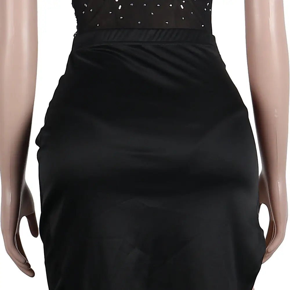 black satin skirt with a fitted waistband and subtle sheen as part of a rhinestone sling backless two-piece set available in two colors
