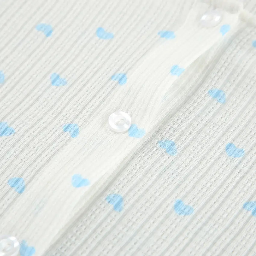 A knitted heart printing ribbed loungewear set in delicate white fabric with light blue heart patterns and clear buttons showcasing heart printing comfortable design.